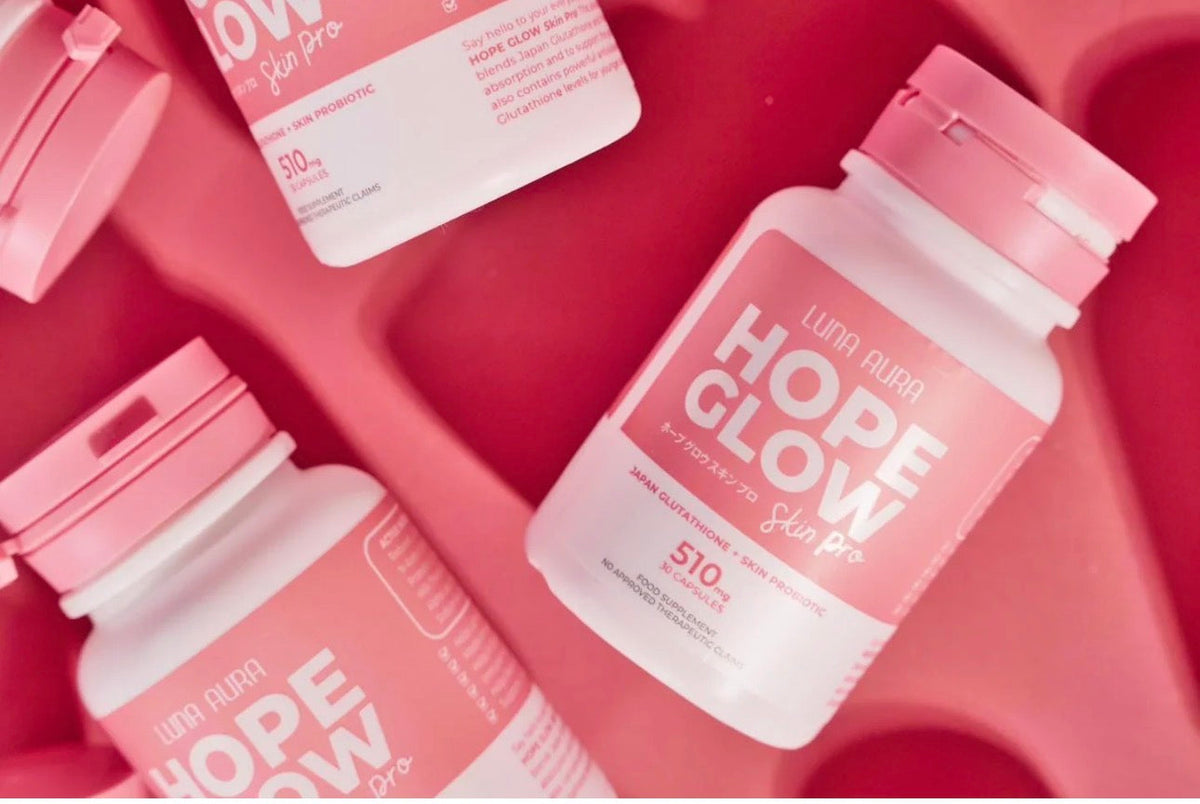 Flacons Hope Glow Skin Pro vus de dessus sur fond rose