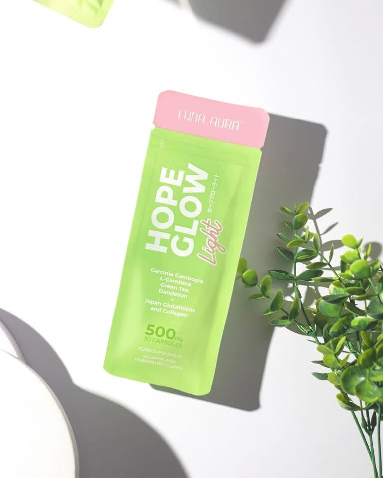 Sachet vert Hope Glow Light de Luna Aura posé près d'un feuillage
